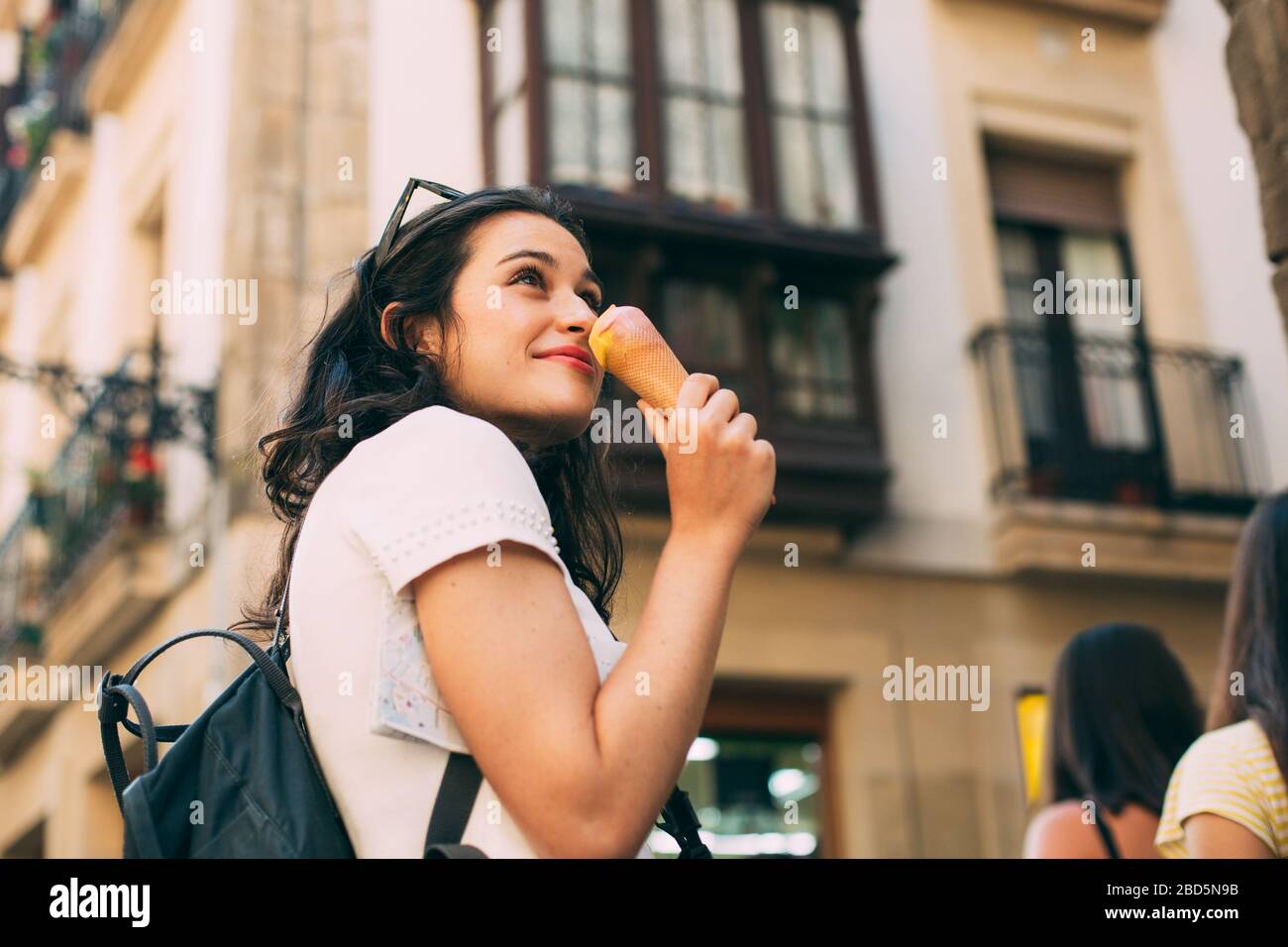 Jeune femme touristique qui aime et glace tout en visitant une ville européenne Banque D'Images