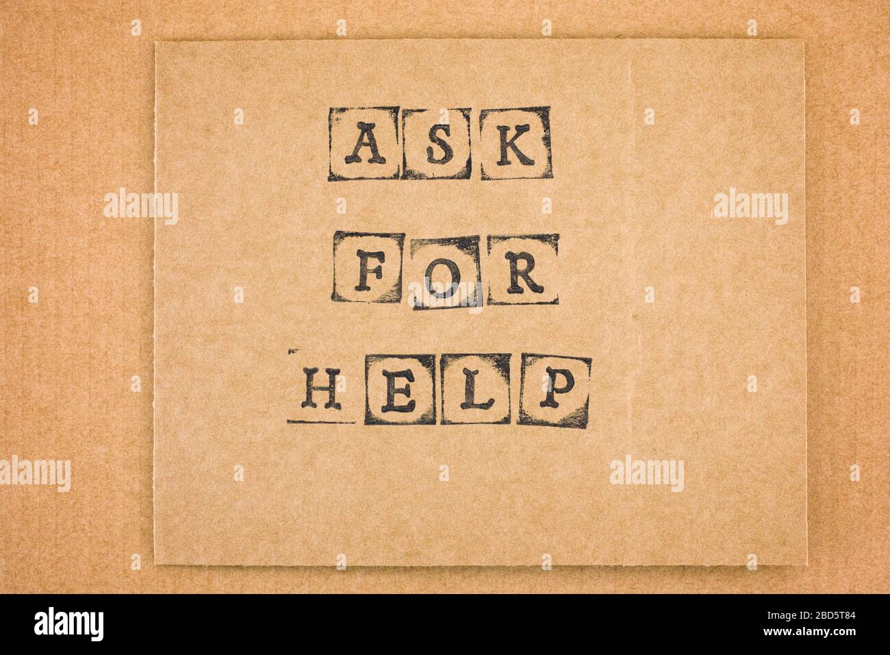 Carton avec mots demander de l'aide faite par des timbres de l'alphabet noir. Banque D'Images