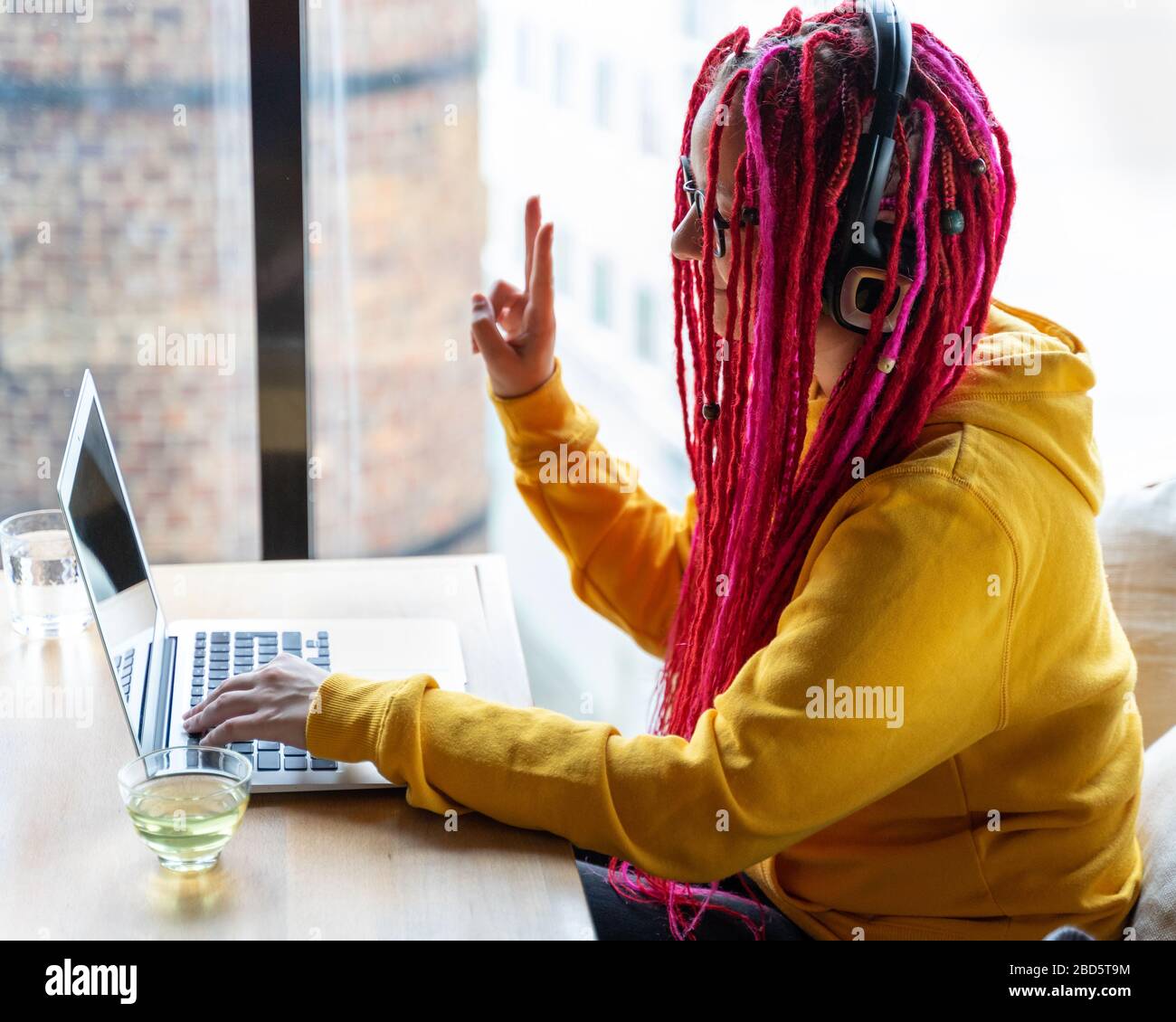 Concept de nomade numérique. Fille freelance travaillant à distance sur ordinateur portable dans le café, collègue. Banque D'Images