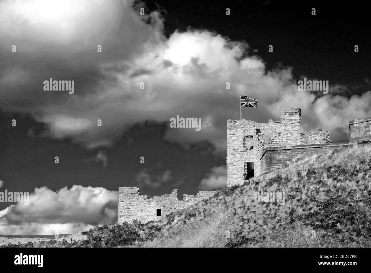 Château et murs de Tynemouth avec pavillon Union ciel lumineux et nuage en monochrome Banque D'Images