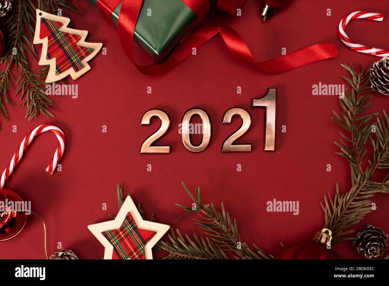Bonne année 2021. Chiffres d'or 2021 avec chapeau de Noël sont sur fond rouge avec des paillettes. Partie de la décoration de maison de vacances ou une carte postale concept avec top v Banque D'Images