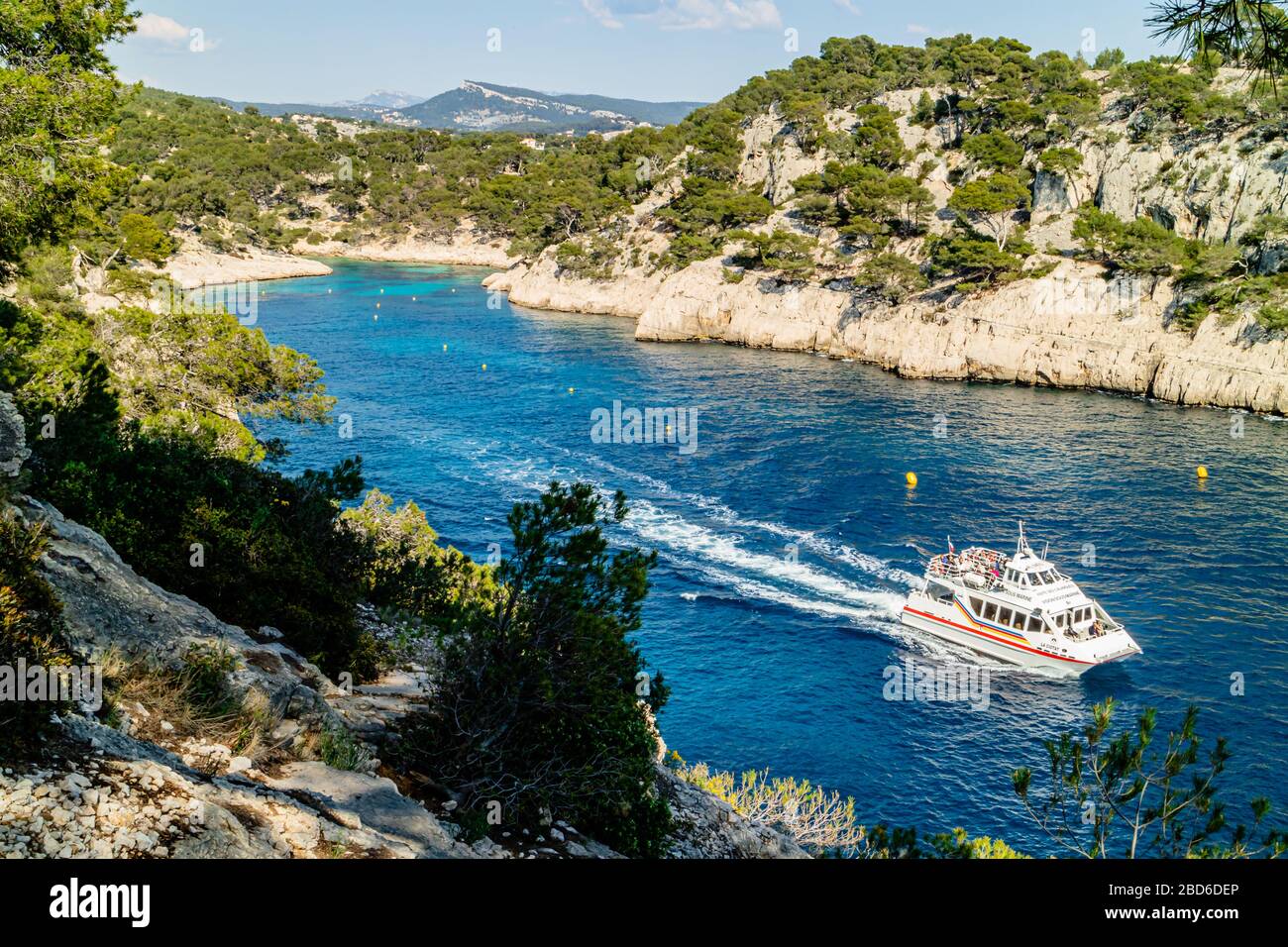 Vue sur la Calanque de Port PIN avec un bateau touristique, Parc National de Calanques, près de Cassis, côte sud de la France. Printemps 2017. Banque D'Images