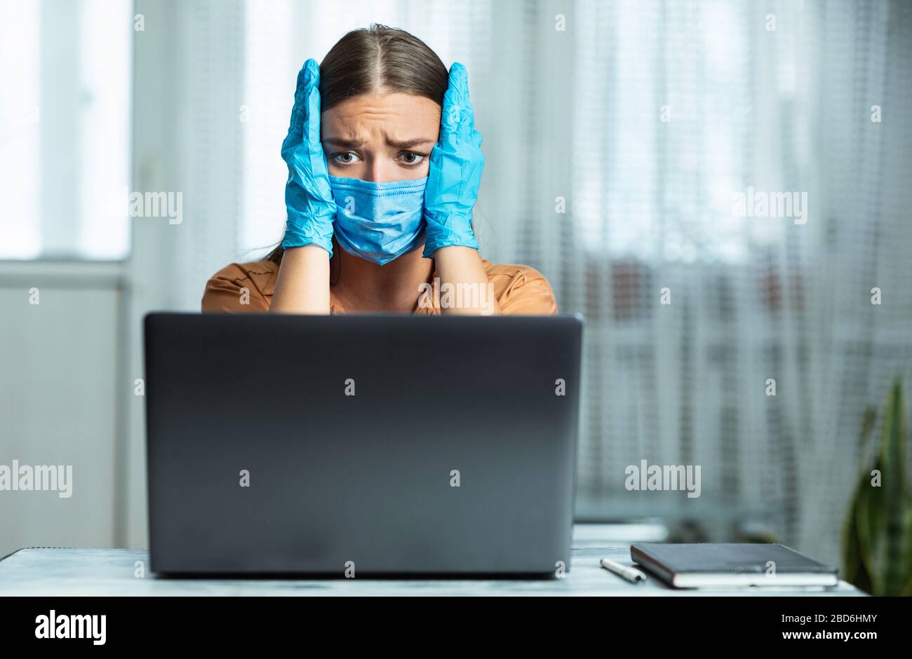 Femme en quarantaine portant un masque et des gants en regardant les nouvelles Banque D'Images