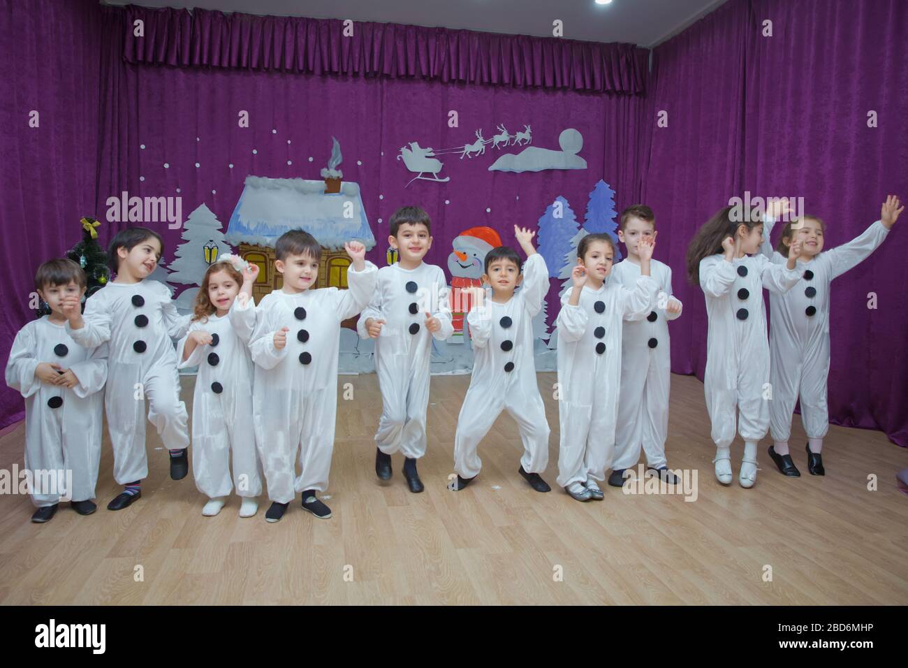 Les enfants sont habillés comme des bonhommes de neige. Les participants à la maternelle participent à un événement du nouvel an. Mignons garçons vêtus de costumes festifs du Père Noël Banque D'Images