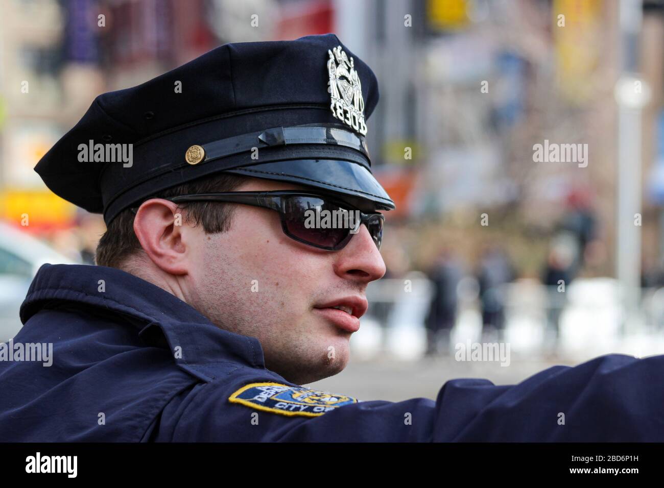 Officier de police du NYPD avec bouchon à pic et lunettes de soleil pointant vers des directios à Manhattan, New York City, États-Unis d'Amérique Banque D'Images