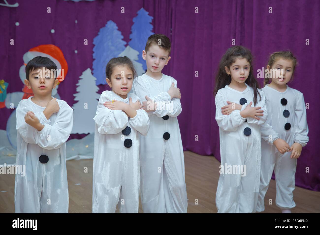 Les enfants sont habillés comme des bonhommes de neige. Les participants à la maternelle participent à un événement du nouvel an. Mignons garçons vêtus de costumes festifs du Père Noël Banque D'Images