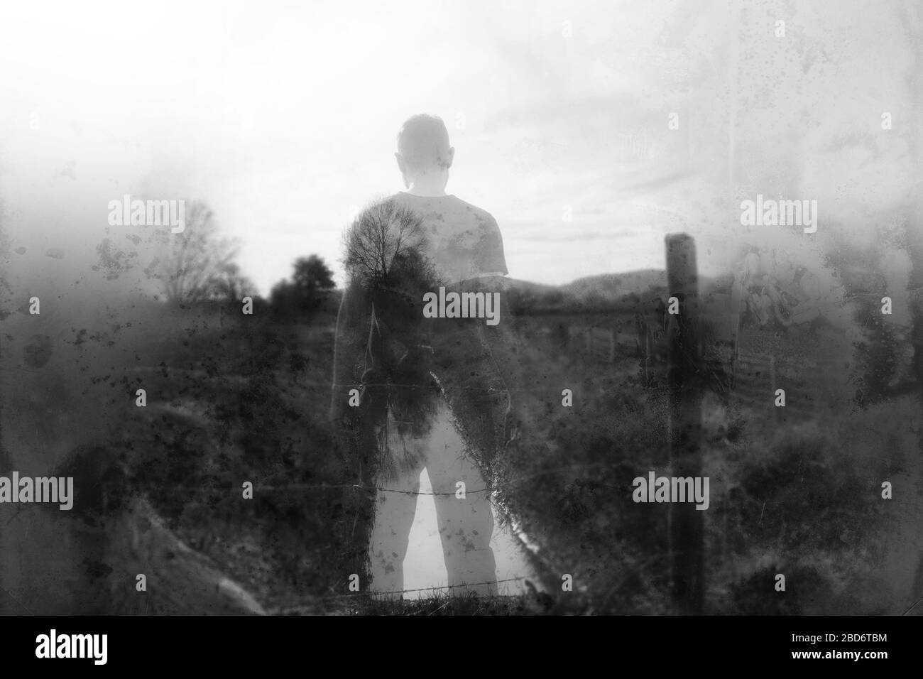 Une journée d'hivers et une figure masculine semi-transparente se tenant au-dessus d'un ruisseau dans la campagne. Avec un montage abstrait flou, texturé, dérésonné. Banque D'Images