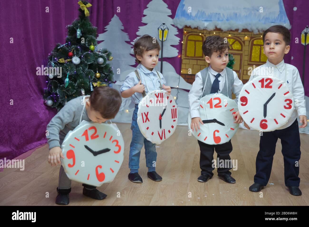 Les enfants . Les participants à la maternelle participent à un événement du nouvel an. Des petits garçons vêtus de costumes festifs de costume. Un enfant joyeux tenant un grand Banque D'Images