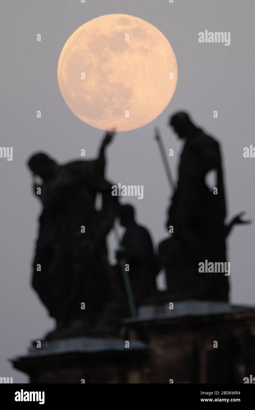 Dresde, Allemagne. 7 avril 2020. La lune s'élève comme un supermond, au premier plan il y a les statues de Mattielli à l'église de la Cour catholique. La lune atteint son périgée, c'est-à-dire le point le plus proche de son orbite à la terre, dans la nuit du 7 au 8 avril comme pleine lune et semble donc être très grande pour l'observateur humain. Crédit: Sebastian Kahnert/dpa-Zentralbild/dpa/Alay Live News Banque D'Images