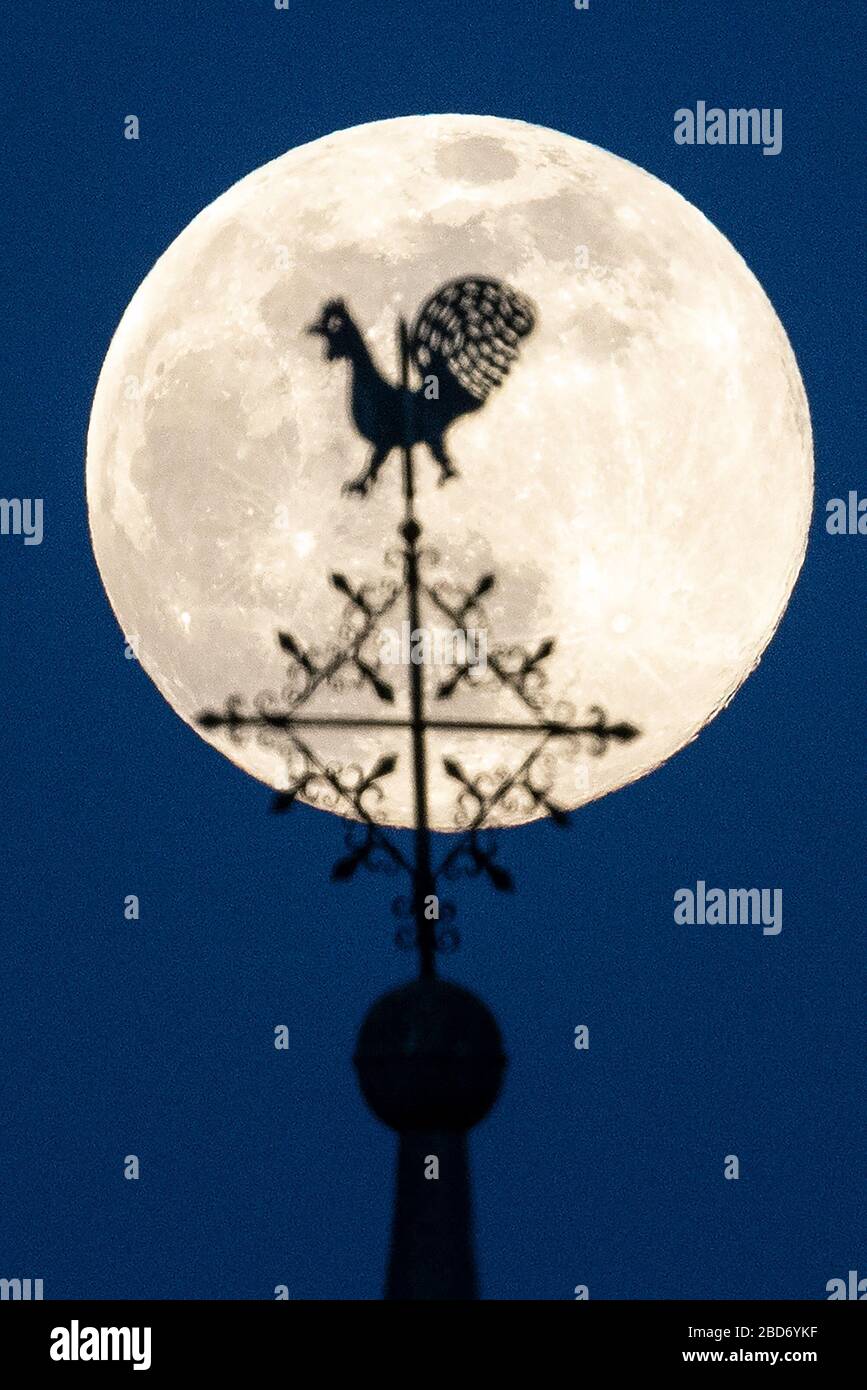 Cologne, Allemagne. 7 avril 2020. La lune se lève comme la soi-disant super pleine lune derrière le weathercock de l'église Sankt Jakobus à Cologne-Widdersdorf. La lune atteint son périgée, c'est-à-dire le point le plus proche de l'orbite de la Terre, dans la nuit des 7-8 avril comme pleine lune et apparaît donc particulièrement grand pour l'observateur humain. Crédit: Federico Gambarini/dpa/Alay Live News Banque D'Images