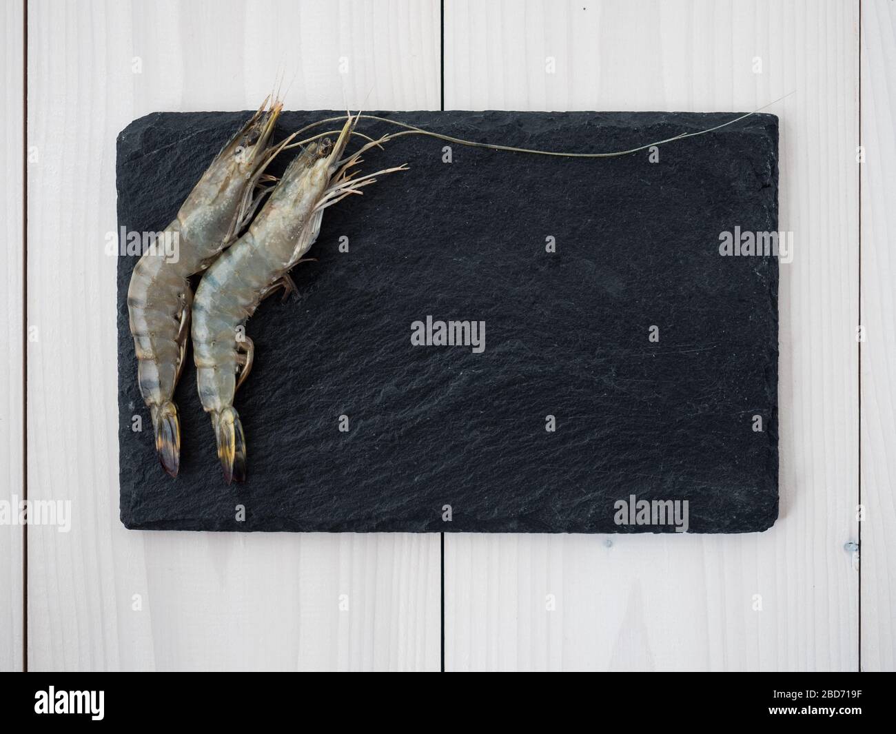 crevettes non cuites sur tableau ardoise. vue de dessus Banque D'Images
