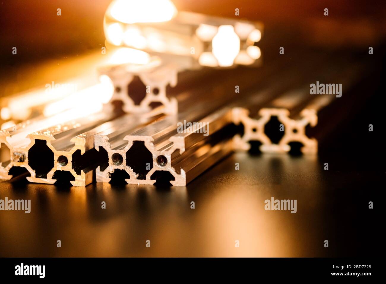 le profil en aluminium à rainure en v se trouve sur une table noire, une surface de travail avec une lanterne lumineuse. comment assembler une machine cnc faites-la vous-même Banque D'Images