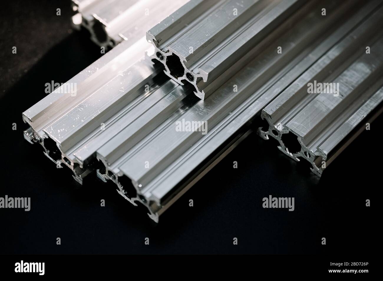 le profil en aluminium à rainure en v se trouve sur une table noire, une surface de travail avec une lanterne lumineuse. comment assembler une machine cnc faites-la vous-même Banque D'Images