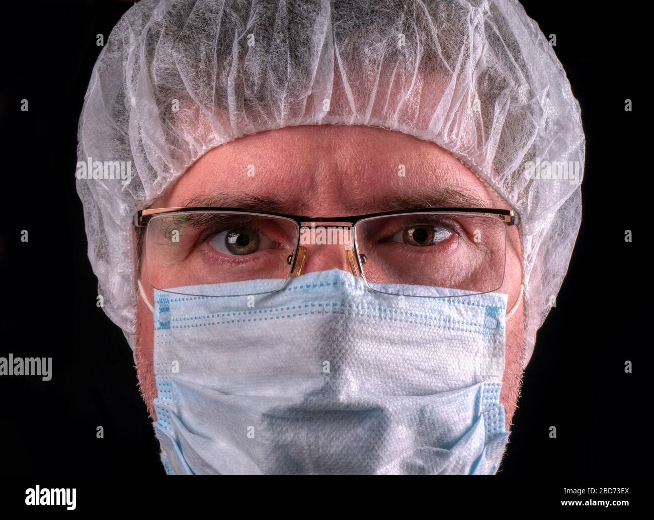 Portrait d'un médecin de sexe masculin portant un masque de protection et des lunettes sur fond noir Banque D'Images