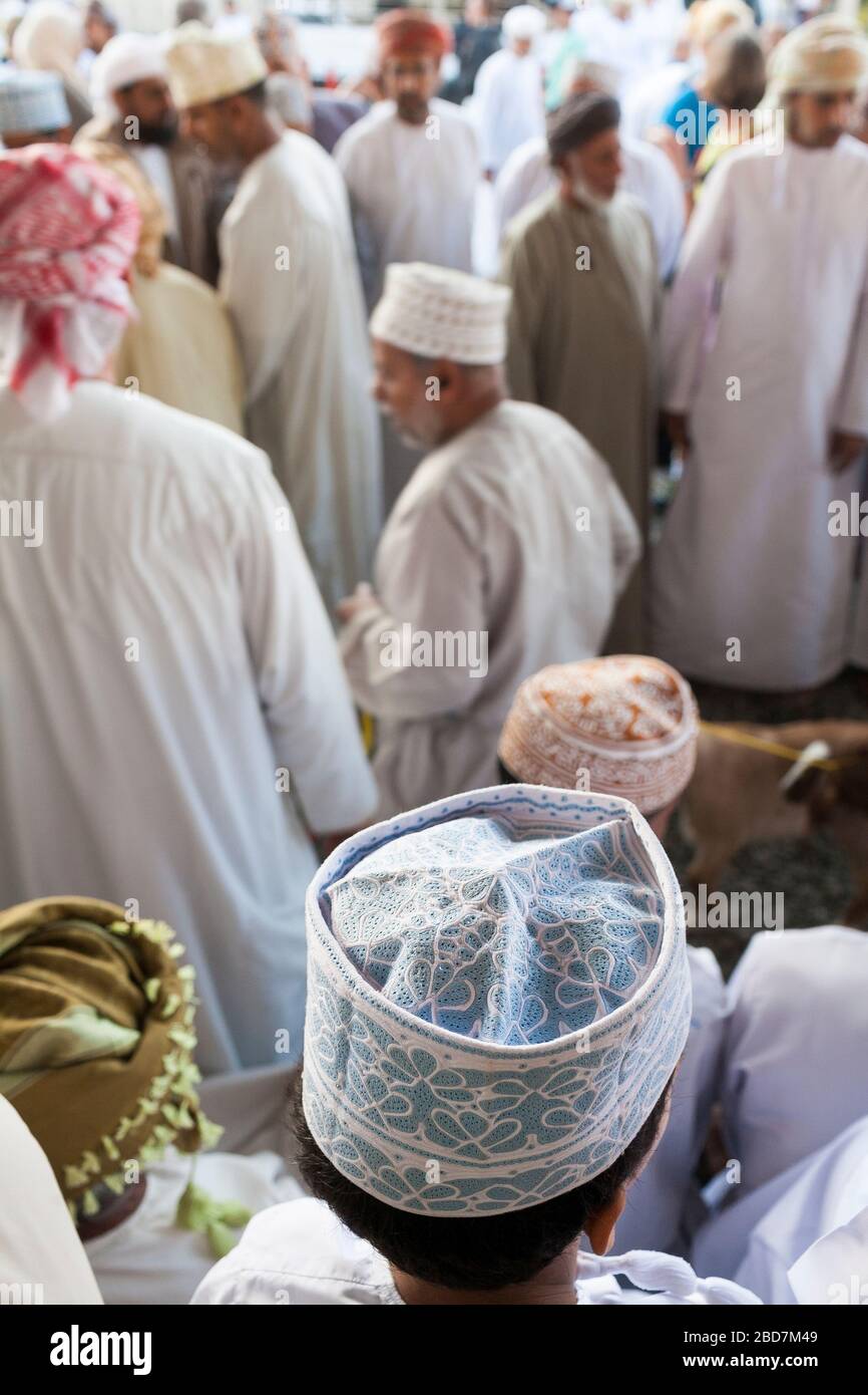 Les hommes et les garçons omanais s'élèvent et se aggle pour le bétail sur le marché du bétail du vendredi dans l'ancien souk de Nizwa en Oman Banque D'Images