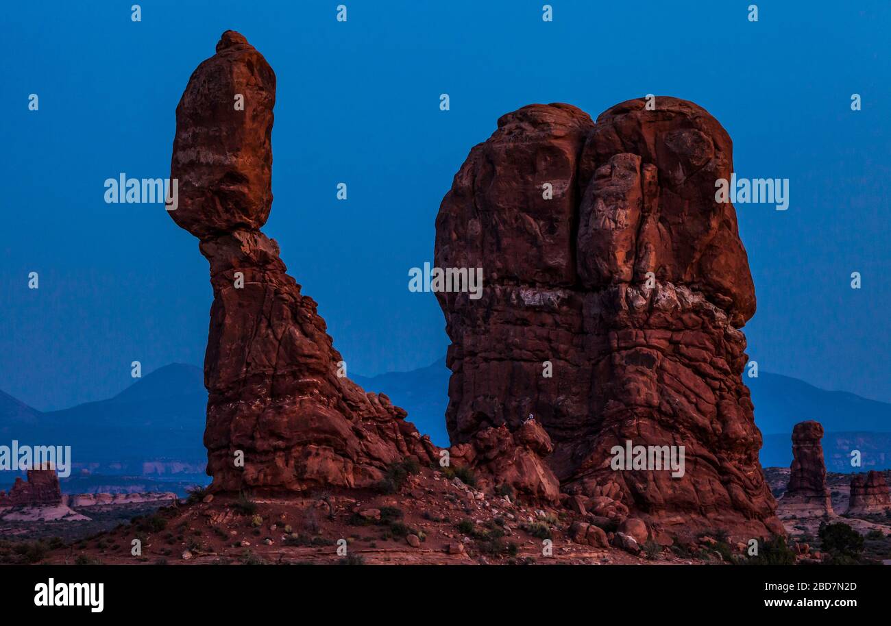 Rock équilibré dans le parc national d'Arches au crépuscule avec les montagnes de la Sal en arrière-plan, Utah, États-Unis. Banque D'Images