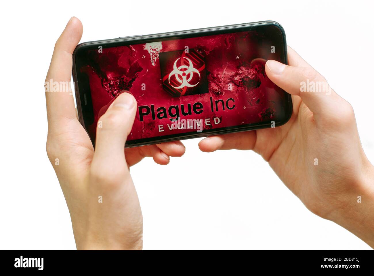 Samara Russie - 04.05.2020: Un jeune homme joue à Plague Inc a évolué sur iPhone 11. Mains isolées d'un homme tenant un smartphone avec un jeu. Banque D'Images