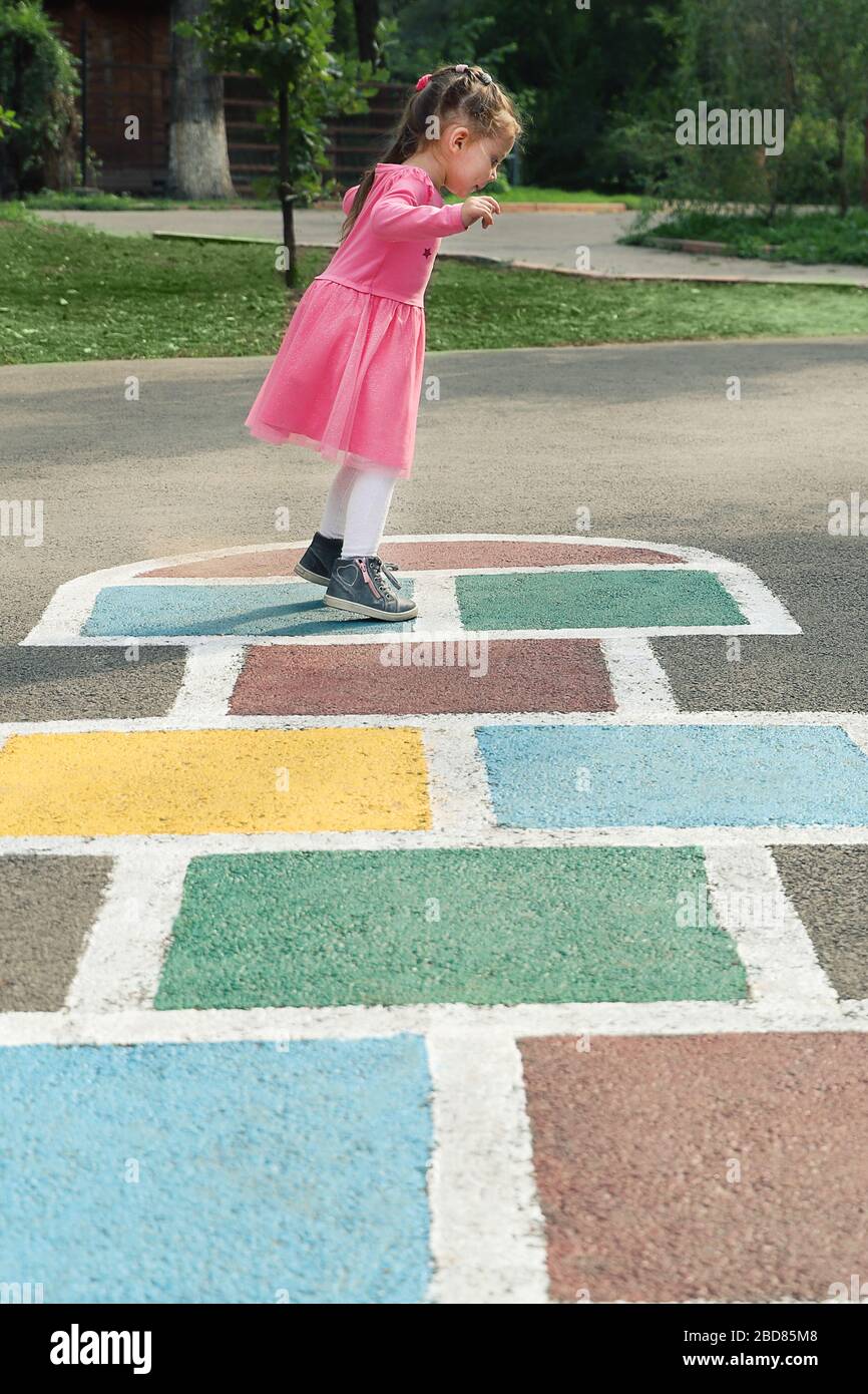 Jeune fille mignonne jouant au hopscotch sur l'arrière-cour Banque D'Images