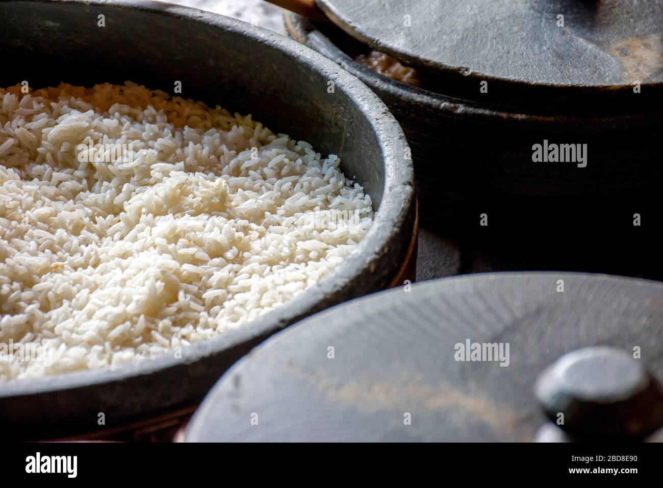 Pots d'argile avec riz blanc préparés sur le poêle à bois et prêts à servir Banque D'Images