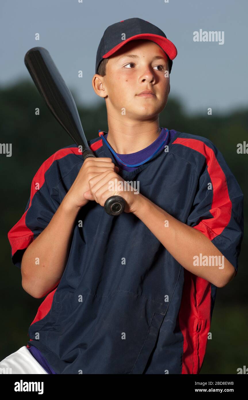 Portrait d'un joueur de baseball tenant sa batte portant une veste d'échauffement Banque D'Images