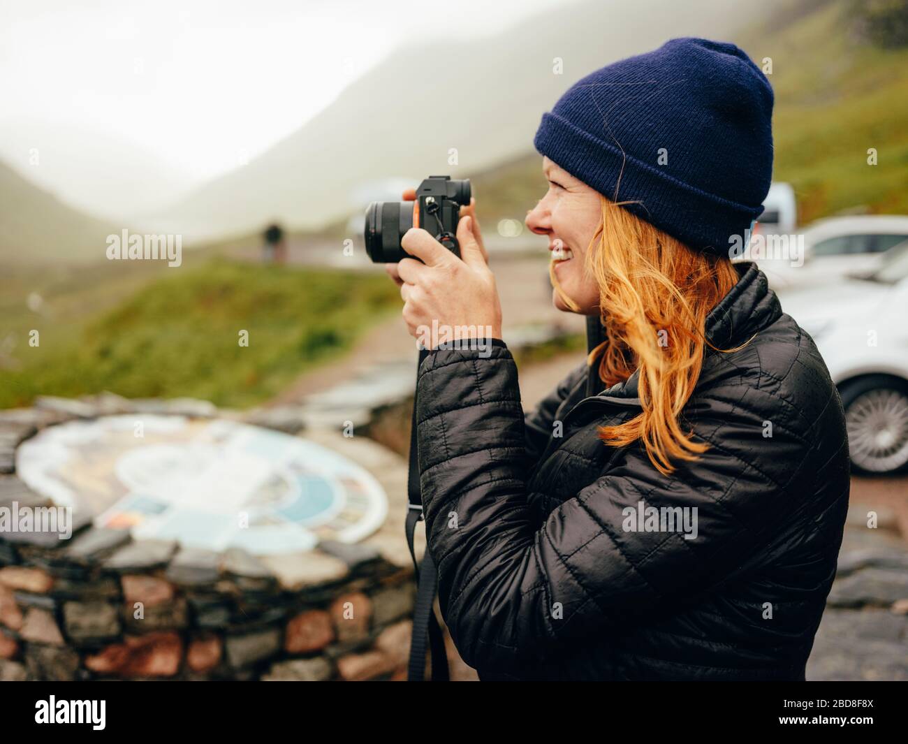 Femme photographiant trois Sœurs de Glencoe, par temps humide Banque D'Images