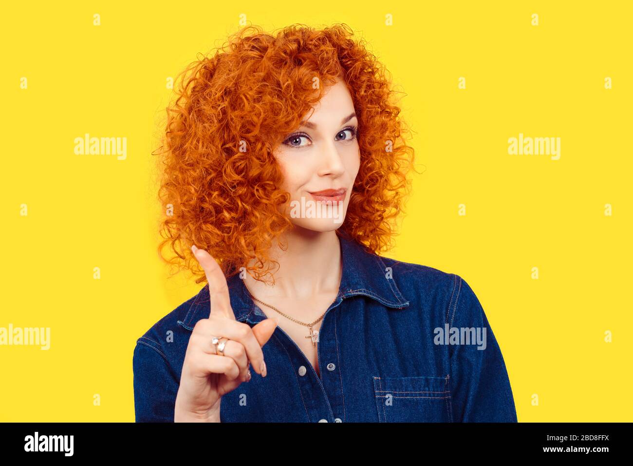 femme gestuelle un pas de signe. Gros plan portrait mécontent, sérieux redhead curly cheveux fille soulevant le doigt vers le haut en disant oh non vous n'avez pas fait ce backgro jaune Banque D'Images