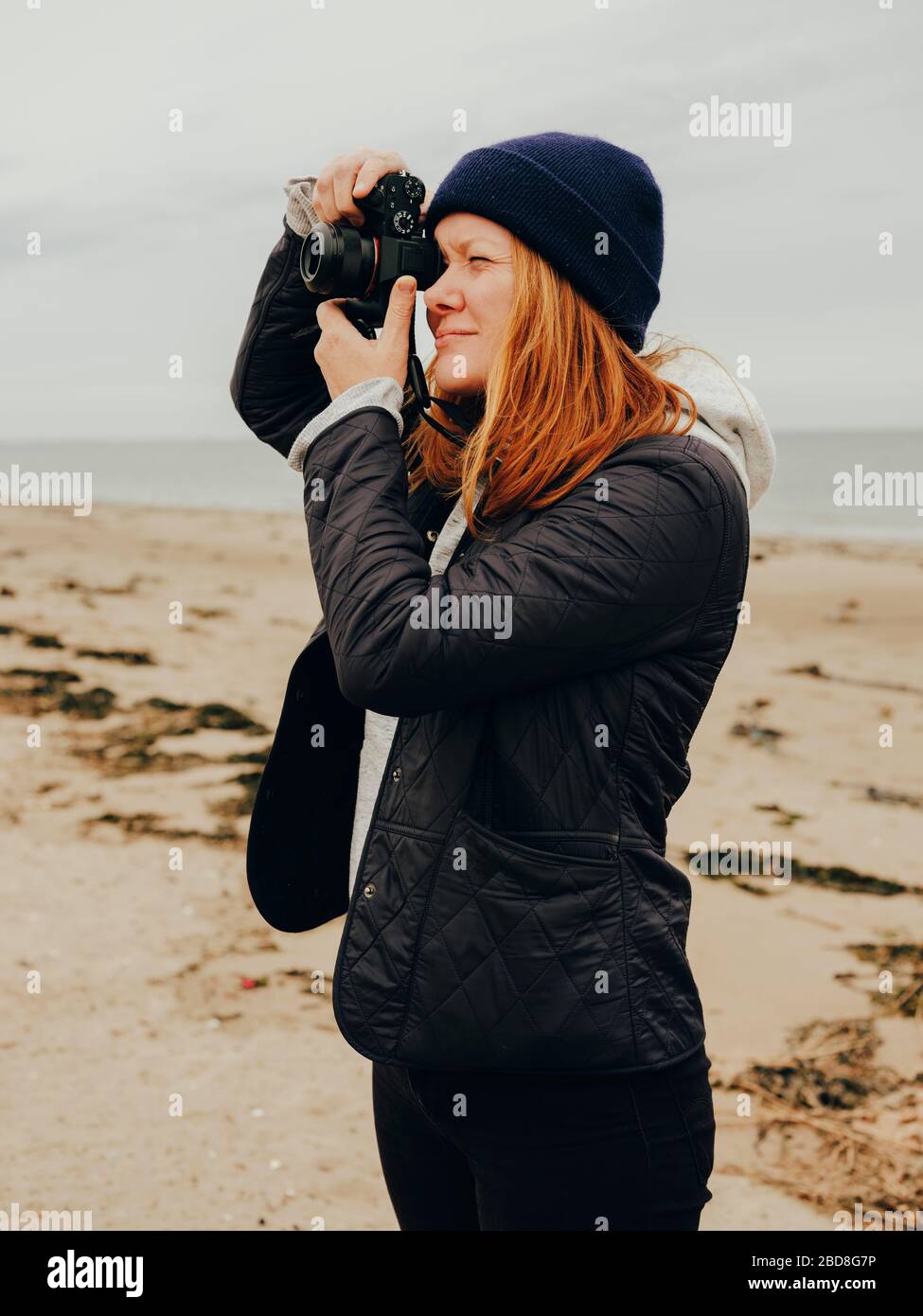 Femme prenant des photos sur la plage en Ecosse Banque D'Images