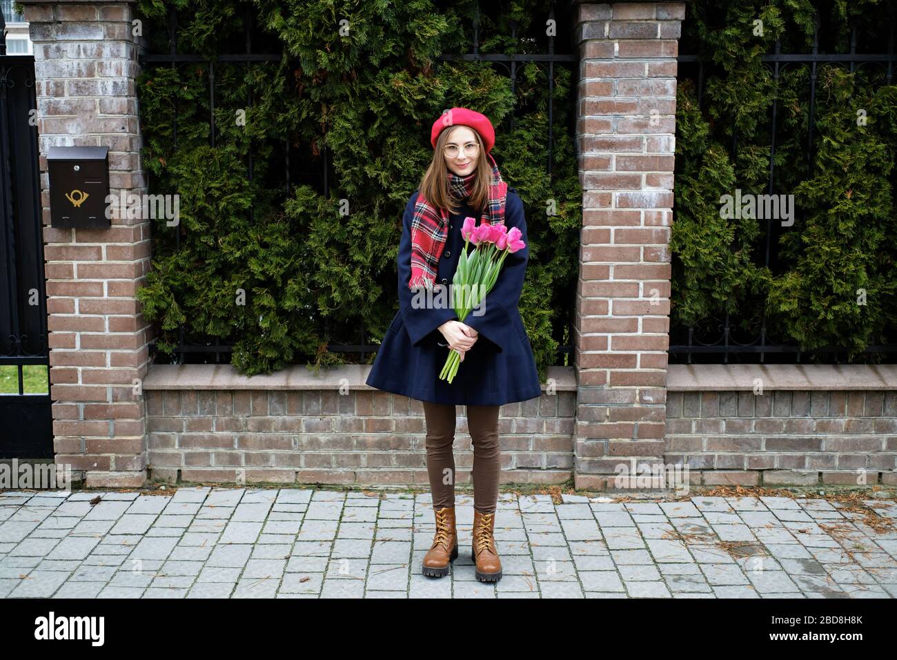 jeune fille millénaire française en béret et manteau avec tulipes dans les  mains Photo Stock - Alamy