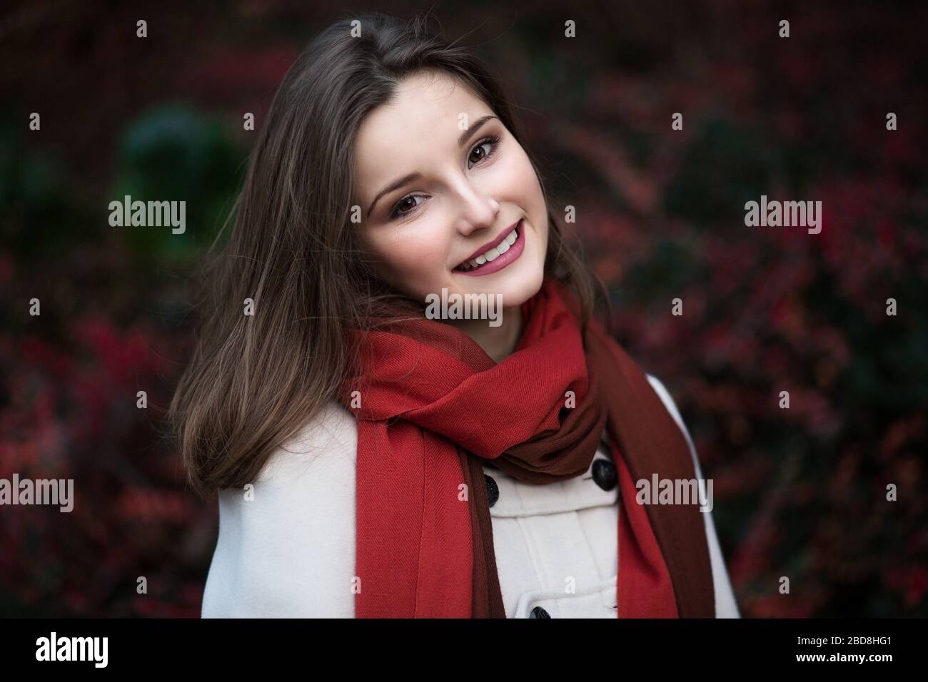 Woman smiling with sourire parfait et des dents blanches dans un parc et looking at camera Banque D'Images