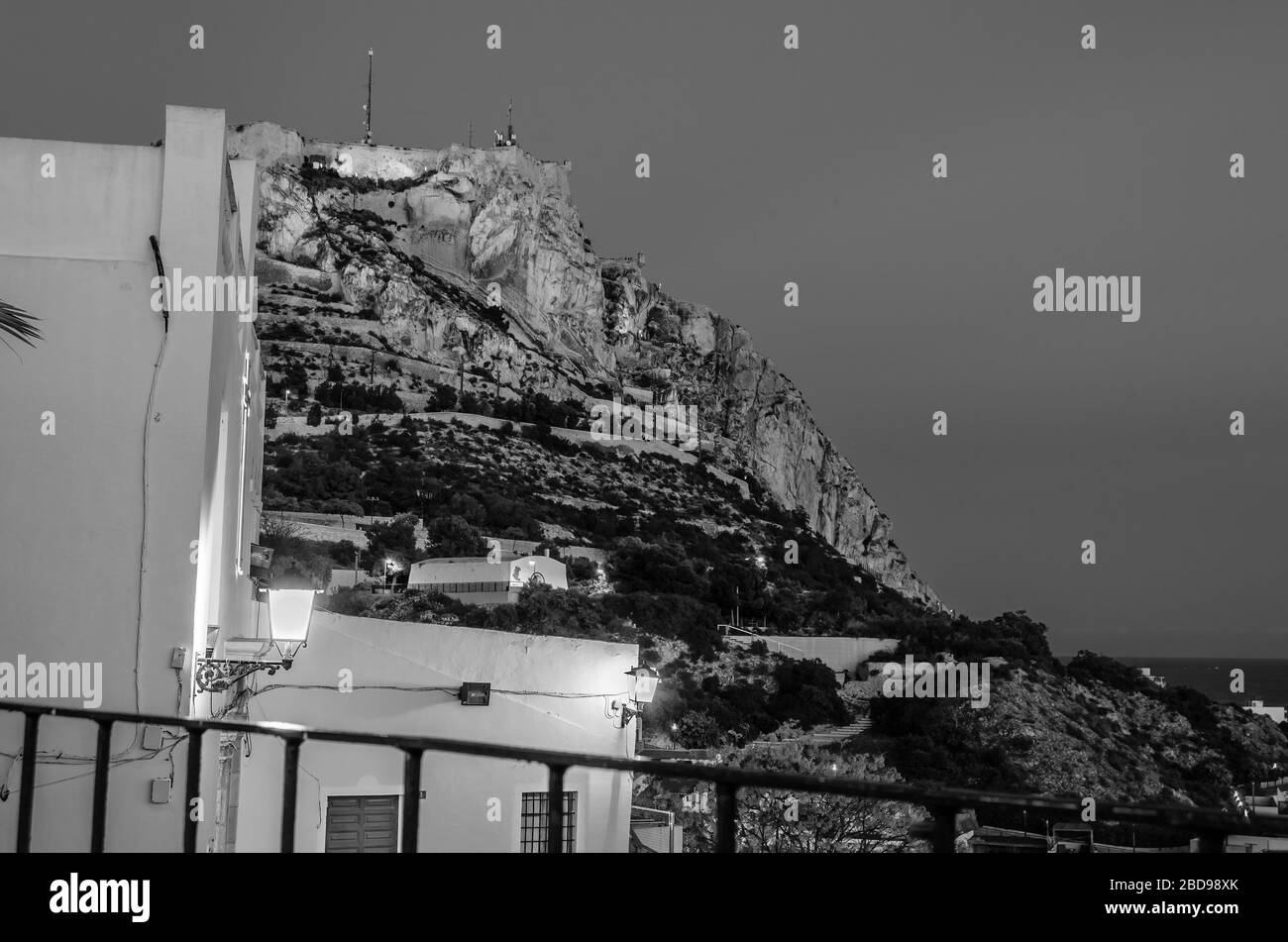 Vue sur le château de Santa Barbara depuis le quartier de Santa Cruz, dans la vieille ville méditerranéenne d'Alicante, en Espagne. Image en noir et blanc Banque D'Images