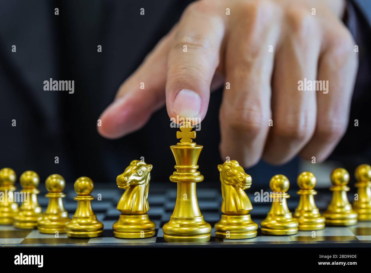 Jeu d'échecs sur le tableau d'échecs derrière l'arrière-plan de l'homme d'affaires. Concept d'affaires pour présenter l'information financière et l'analyse de stratégie de marketing. Investmen Banque D'Images