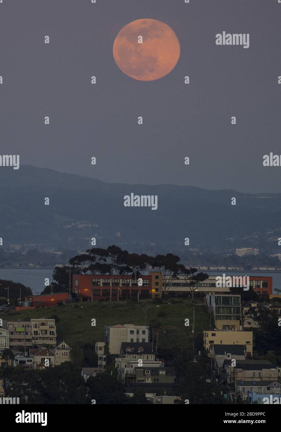 San Francisco, États-Unis. 7 avril 2020. Une super lune rose s'élève à travers la brume derrière Poterero Hill à San Francisco le mardi 7 avril 2020. La pleine lune d'avril est la plus proche de la terre en 2020. Photo de Terry Schmitt/UPI crédit: UPI/Alay Live News Banque D'Images