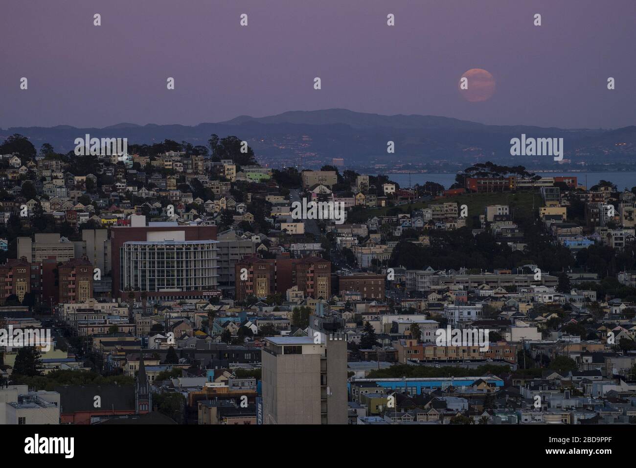 San Francisco, États-Unis. 7 avril 2020. Une super lune rose s'élève à travers la brume derrière Poterero Hill et l'hôpital Zuckerberg San Francisco (L) à San Francisco le mardi 7 avril 2020. La pleine lune d'avril est la plus proche de la terre en 2020. Photo de Terry Schmitt/UPI crédit: UPI/Alay Live News Banque D'Images