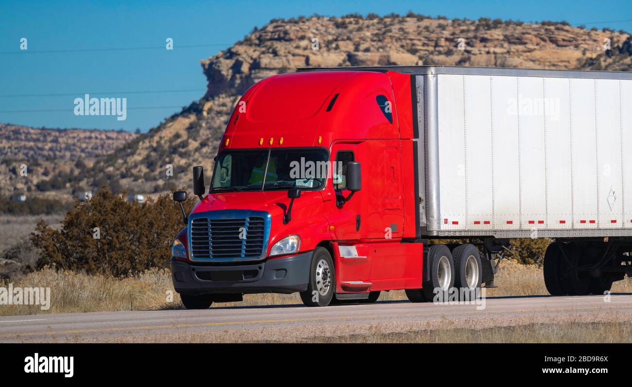 Tracteur de grande plate-forme à dix-huit roues avec remorque sur route. Industrie du camionnage Banque D'Images