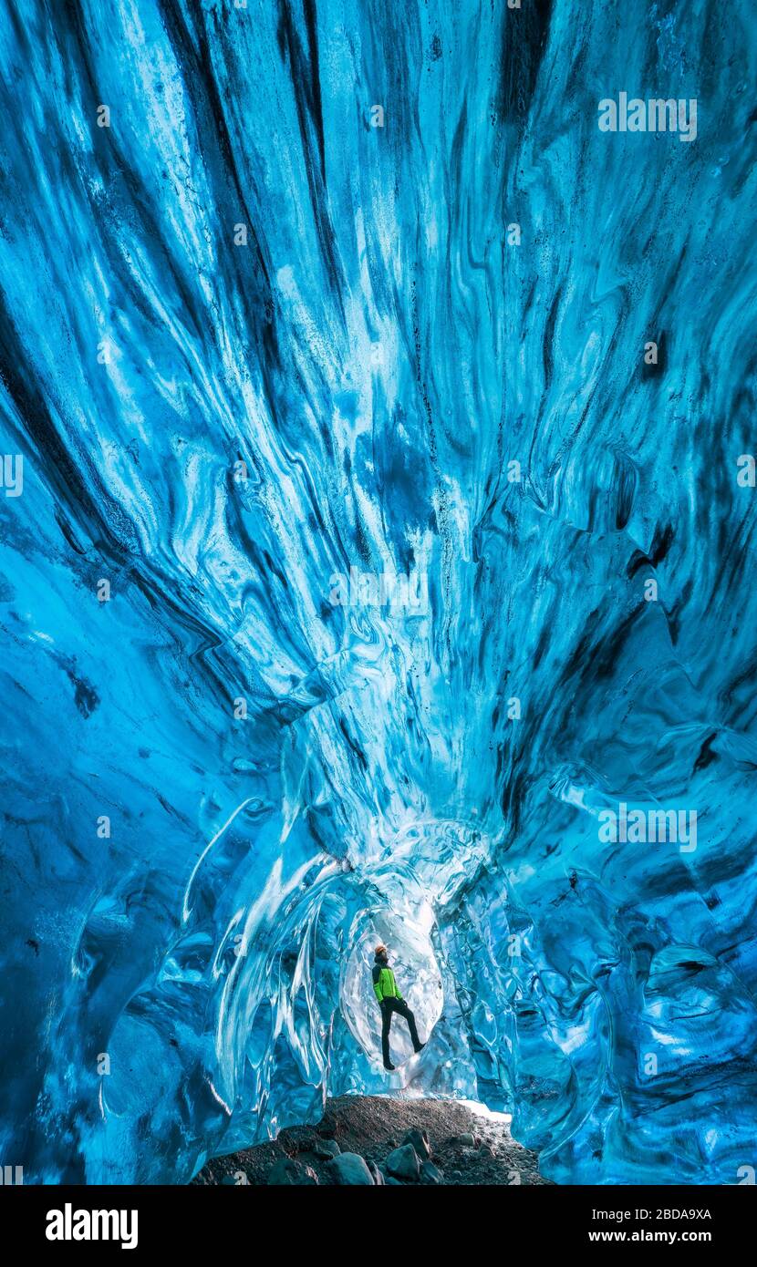 L'homme observe dans une grotte de glace de Breidamerkurjokull, Austurland, Islande, Europe du Nord Banque D'Images