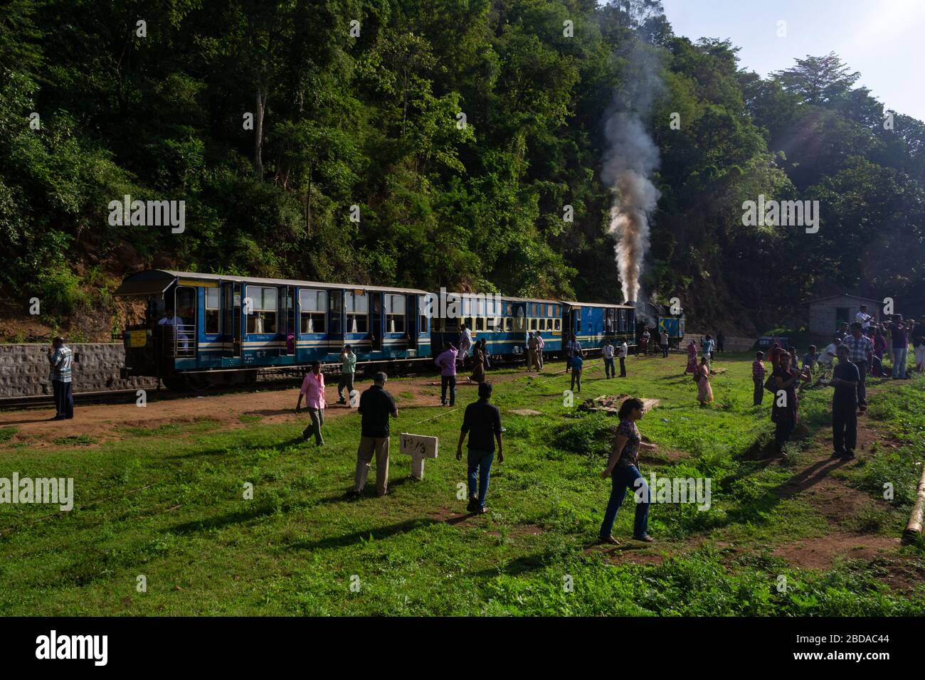 Les passagers s'enprennent du train pour une courte pause dans l'un des haltes du Nilgiri Mountain Railway, Tamil Nadu, Inde Banque D'Images