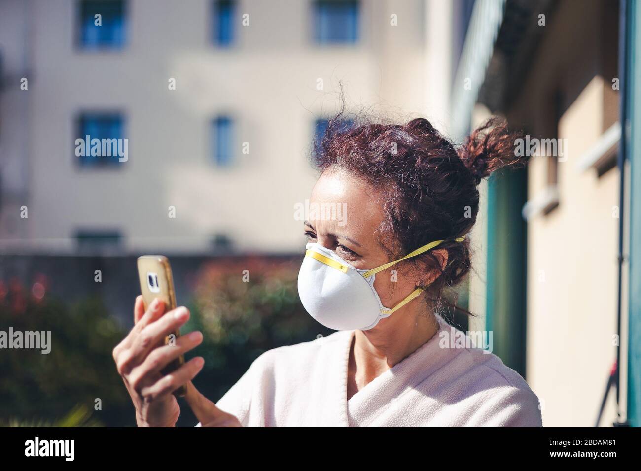 Femme avec expression inquiète, cheveux coumousled et masque pour la quarantaine de coronavirus Banque D'Images