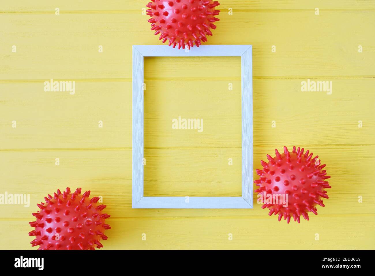 Modèle abstrait de souche de virus de boules rouges avec cadre en bois sur fond jaune. Syndrome respiratoire coronavirus et novel coronavirus covid-19 avec Banque D'Images