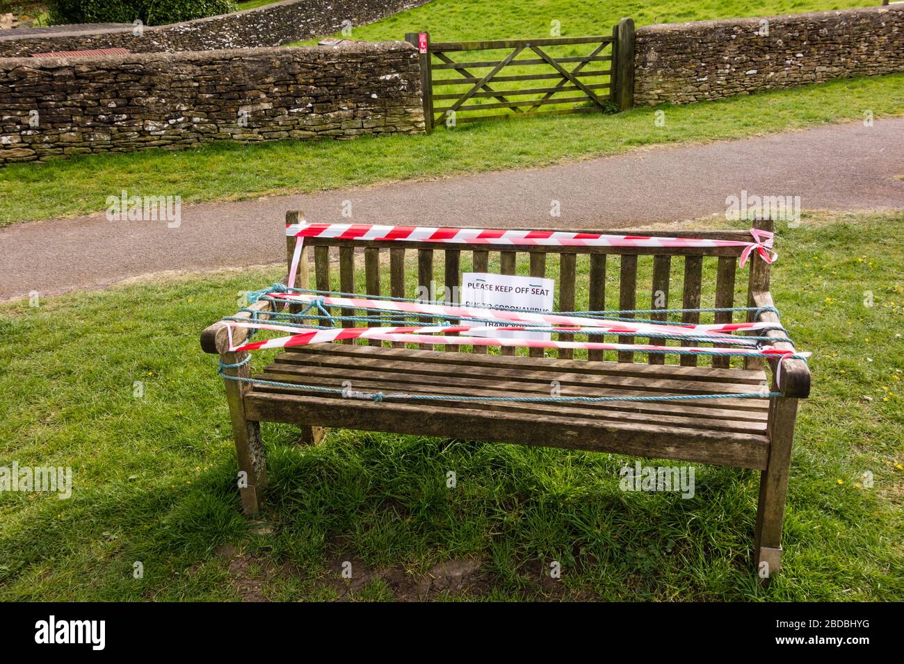 Garez le banc avec panneau de ne pas s'asseoir et ruban d'avertissement blanc et rouge, Tetbury, Gloucestershire, Royaume-Uni Banque D'Images