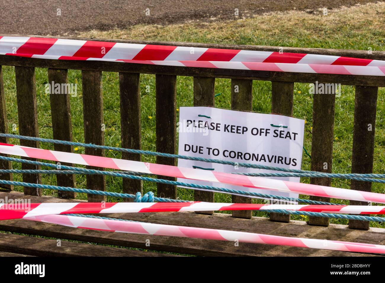 Garez le banc avec panneau de ne pas s'asseoir et ruban d'avertissement blanc et rouge, Tetbury, Gloucestershire, Royaume-Uni Banque D'Images