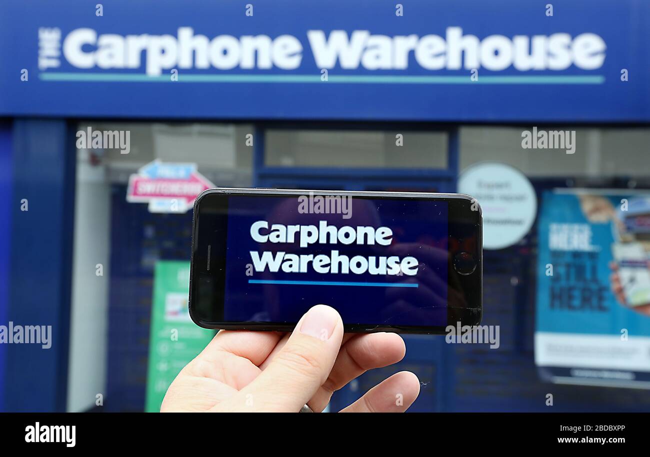 Une image générique du logo Carphone Warehouse sur un smartphone avec la boutique visible derrière. Banque D'Images