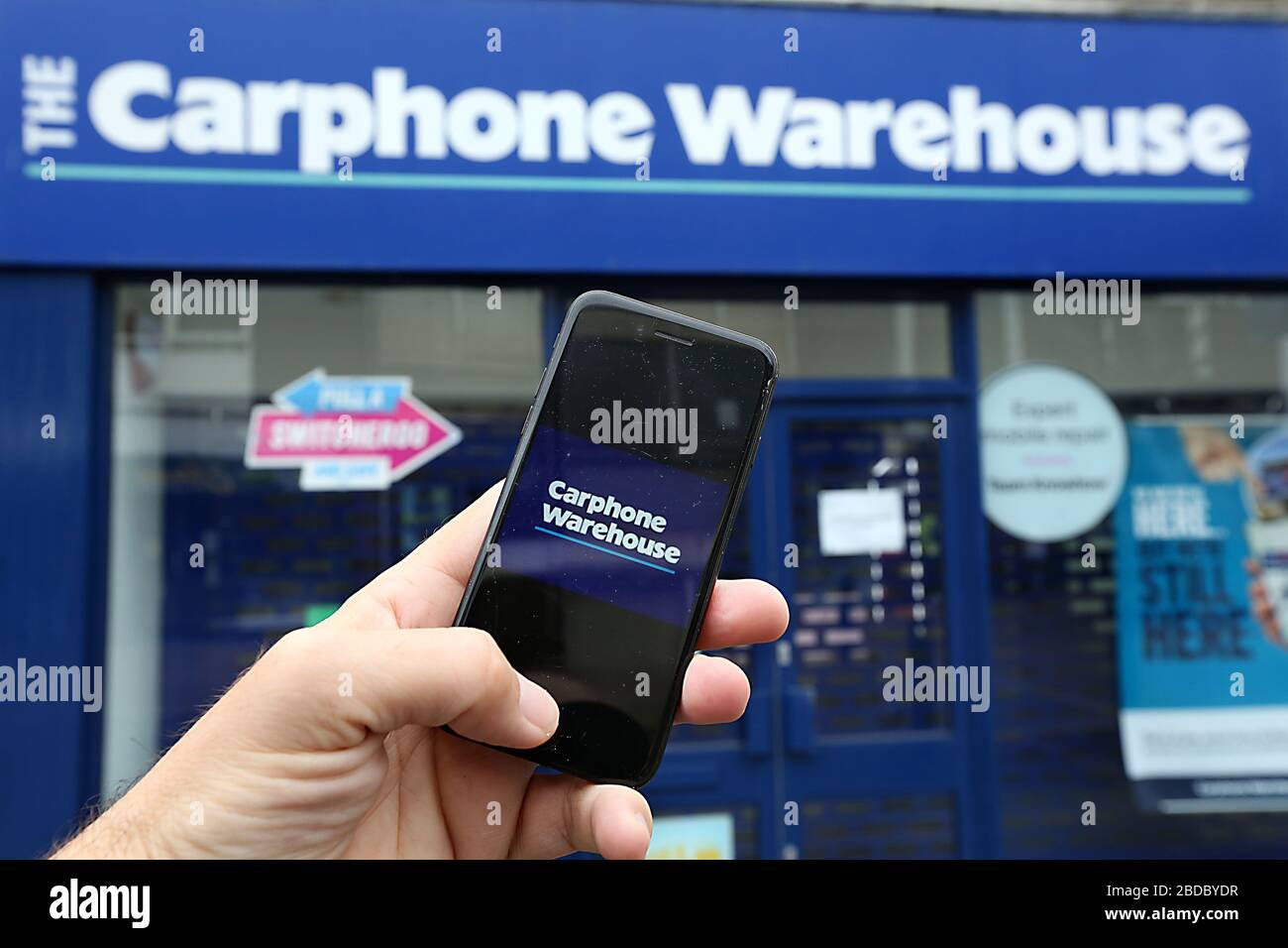 Une image générique du logo Carphone Warehouse sur un smartphone avec la boutique visible derrière. Banque D'Images