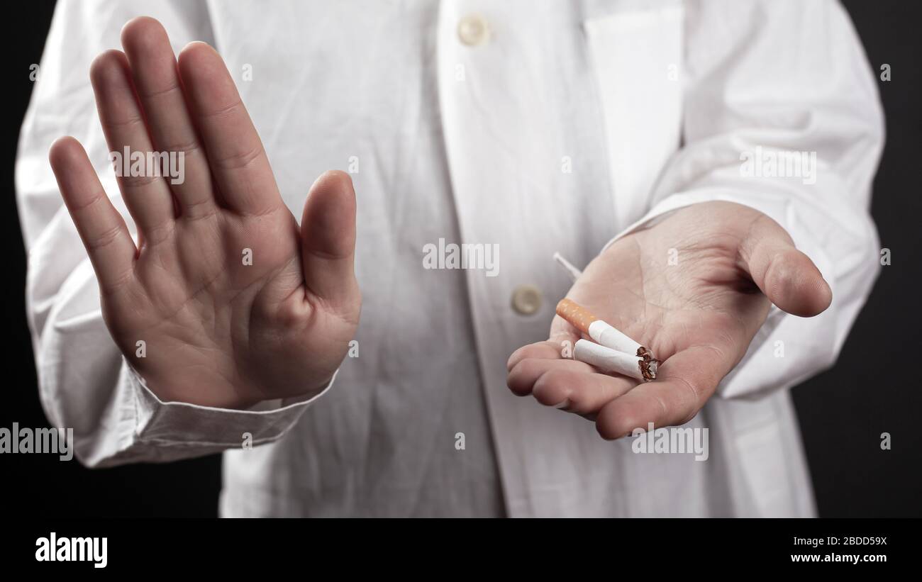 cessez de fumer, une cigarette cassée entre les mains d'un médecin. Banque D'Images