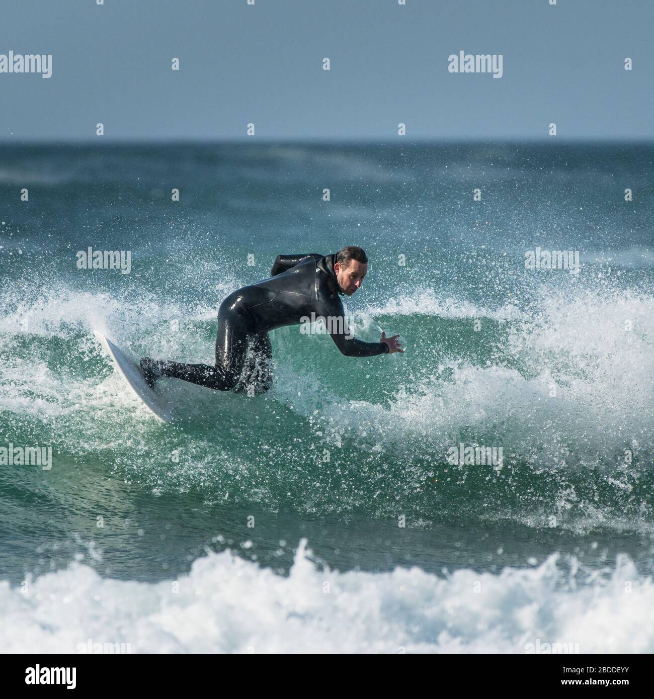 Un surfeur mûr profitant des conditions de surf spectaculaires à Fistral à Newquay, dans les Cornouailles. Banque D'Images