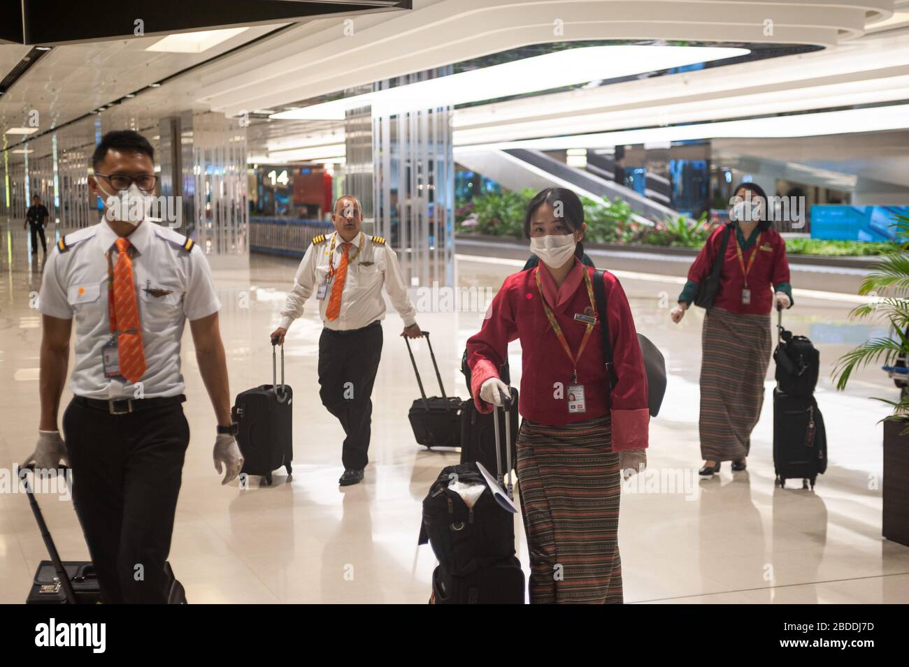 28.03.2020, Singapour, , Singapour - pilotes et agents de bord de Druk Air du Bhoutan porter des respirateurs et des gants en caoutchouc à leur arrivée au terminal Banque D'Images