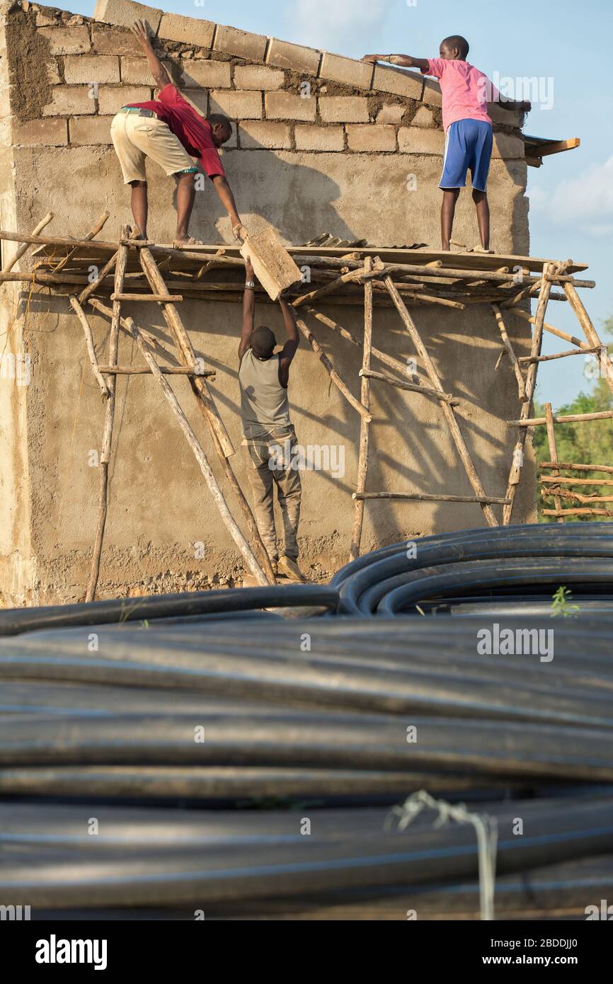 11.11.2019, Burferedo, région somalienne, Ethiopie - les travailleurs de la construction se tiennent sur un échafaudage en bois non sécurisé et en ont établi des briques en béton. Au premier plan Banque D'Images