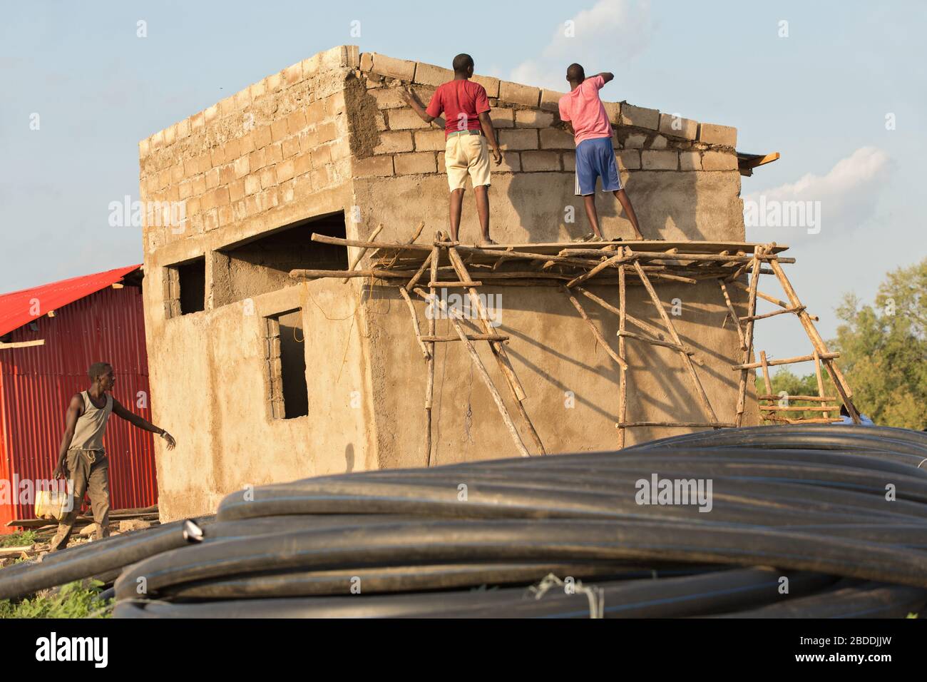 11.11.2019, Burferedo, région somalienne, Ethiopie - les travailleurs de la construction se tiennent sur un cadre en bois non sécurisé et ont établi des briques en béton. Au premier plan ro Banque D'Images