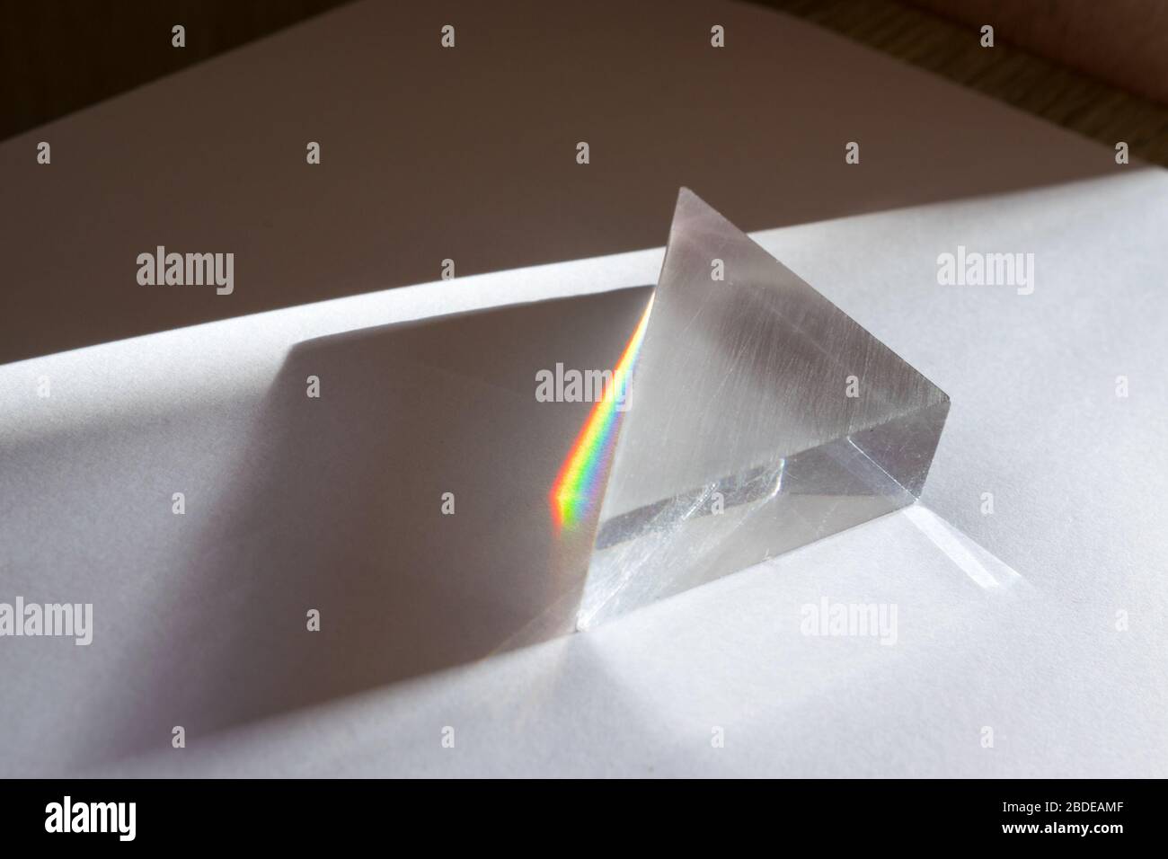 Spectre Rainbow de couleurs causé par la rupture et la dispersion de la lumière du soleil dans un prisme en verre. Expérience physique. Banque D'Images