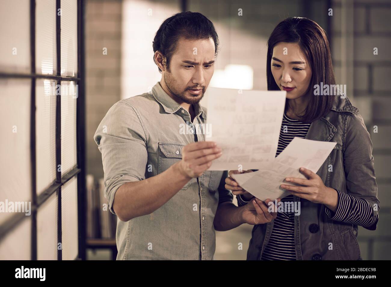 jeunes entrepreneurs asiatiques homme d'affaires et femme d'affaires regardant un document ayant une discussion au bureau Banque D'Images
