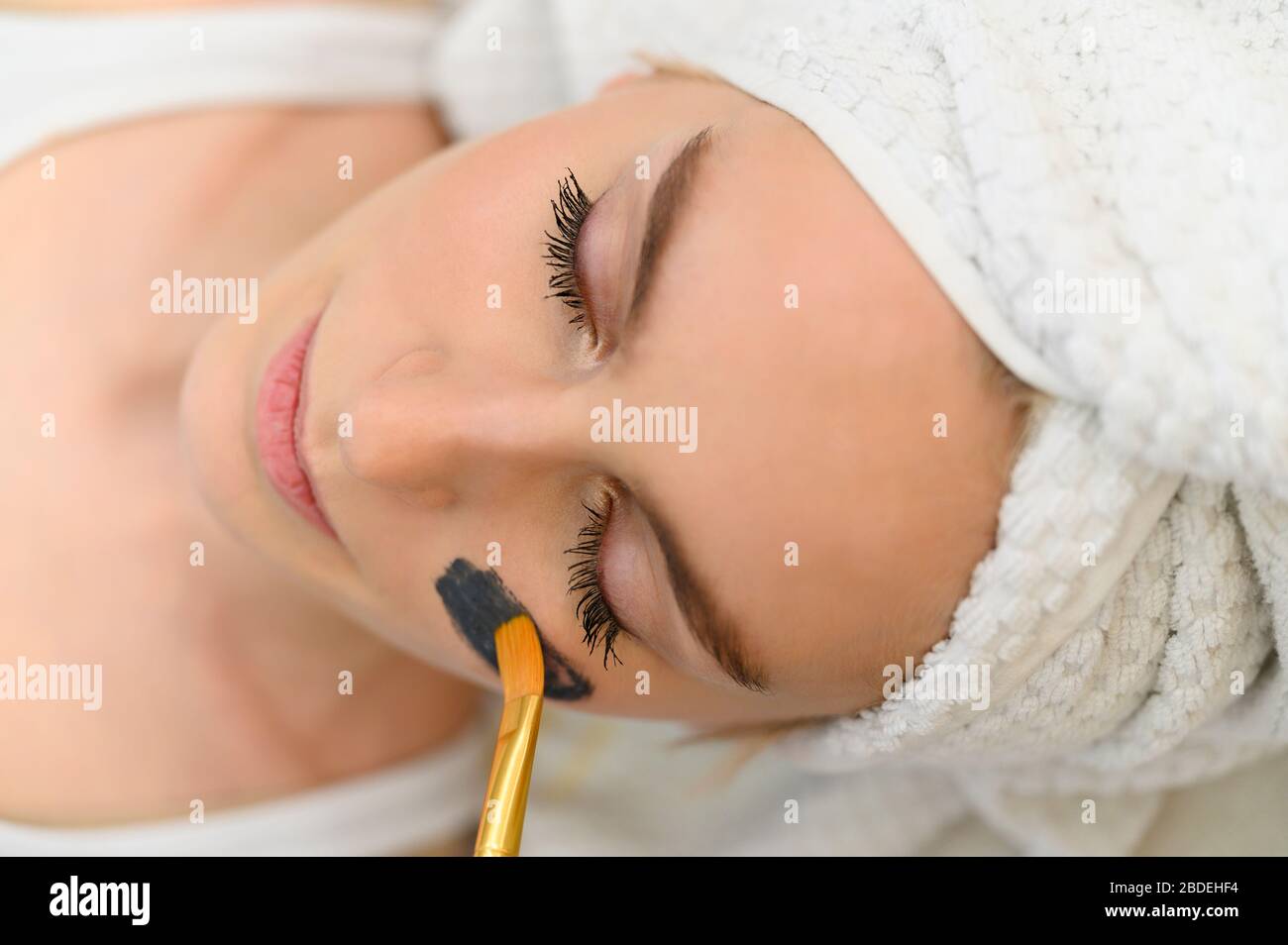 Masque facial appliqué sur le visage de la femme au spa Banque D'Images
